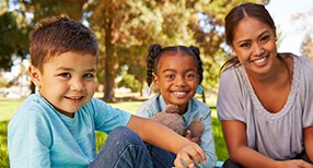 mujer y dos niños sonriendo